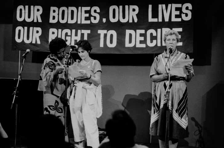 Foto van drie vrouwen die teksten voordragen tijdens het Tribunal and Meeting on Reproductive Rights in Amsterdam